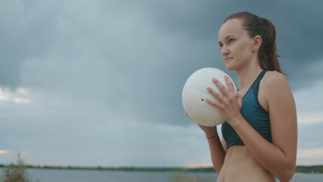 portrait-of-young-sportswoman-with-volleyball-ball-she-is-serving-at-match-on-open-air-court-beach-volleyball