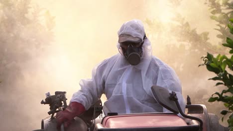 Anonymous-farmer-spraying-pesticide-on-lemon-trees-while-riding-tractor