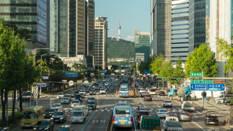 Iconic-N-Seoul-Tower-View-From-Busy-City-Street-Daytime-With-Heavy-Traffic-Near-Sinyongsan-Station-in-Yongsan-District-on-Summer-Day---Dynamic-Timelapse-High-Angle