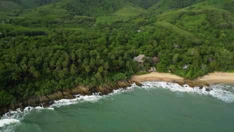 Rocky-cliffside-edge-with-palm-trees-and-sandy-secluded-luxury-hidden-cove-beaches,-koh-lanta-thailand
