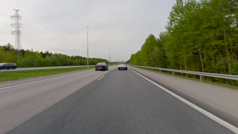 A-car-travelling-very-fast-on-a-highway-lined-by-beautiful-trees