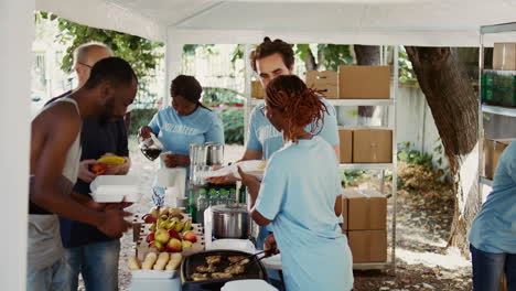 Wohltätigkeitsmitarbeiter-Verteilen-Lebensmittel-An-Bedürftige