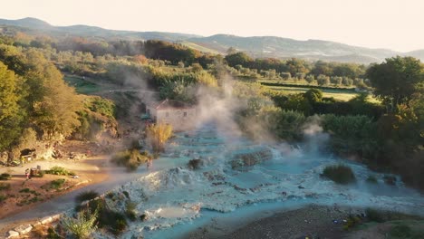 Cascate-del-Mulino,-Soothing-Natural-Hot-Springs-Bath,-Saturnia,-Tuscany,-Italy,-Europe,-Drone-view-traveling-up,-tilt-down