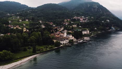 Aerial-shot-pulling-away-from-Bellagio,-Italy's-humble-shoreline-on-a-foggy-day