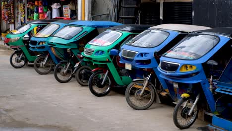 Row-of-colourful-tricycle-motorcycle-taxis-on-the-streets-of-El-Nido-in-Palawan,-Philippines,-Southeast-Asia