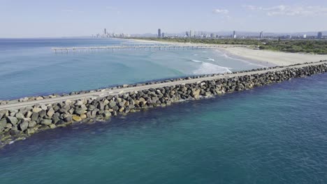 The-Spit-Seawall-With-Sand-Bypass-Pumping-Jetty-In-The-Distance---Main-Beach,-Australia