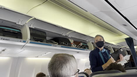 Flight-Attendant-Closing-Overhead-Bins-in-Airplane-Cabin-as-Passengers-Board-at-LAX-Airport-on-7-13-2023