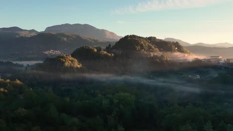 Luftdrohnenaufnahme-Eines-Waldes-Mit-Nebel-Zur-Goldenen-Stunde-Am-Morgen,-Hügel-Und-Berg-Im-Hintergrund,-Toskana,-Italien,-Europa