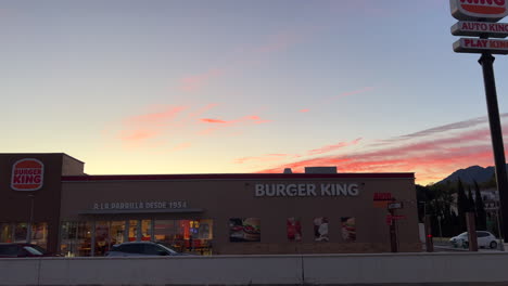 Fuera-De-Burger-King-Con-Hermosa-Puesta-De-Sol-Y-Nubes-Rosadas-En-Estepona-España,-Restaurante-De-Comida-Rápida,-Toma-De-4k