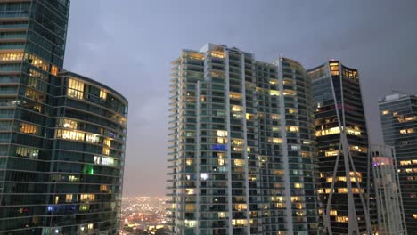 Aerial-tilt-down-of-skyscraper-buildings-illuminated-at-night-in-Miami-downtown