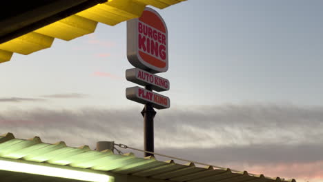 Burger-King,-Auto-King-and-Play-King-sign-with-beautiful-sunset-in-Estepona-Spain,-4K-shot