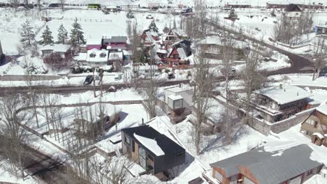 Flyover-in-the-snow-filled-mountain-village-of-Farellones-with-clear-streets-and-leafless-trees-on-a-sunny-winter-day
