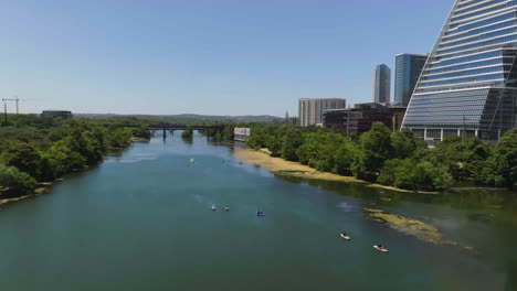 Drone-shot-tilting-over-kayaks-on-the-Colorado-river-in-sunny-day-in-Austin,-USA