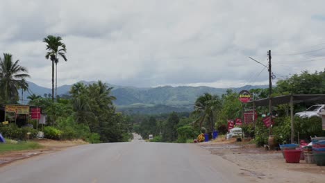 POV-Driving-backward-drive-through-a-mountainous-rural-town-misty-rainforest-mountain