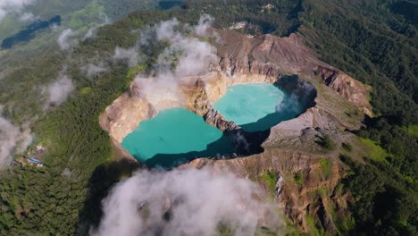 Una-Toma-Aérea-De-Lagos-Azules-De-Cráter-Volcánico-En-La-Cima-De-Una-Colina-Con-Un-Gran-Bosque