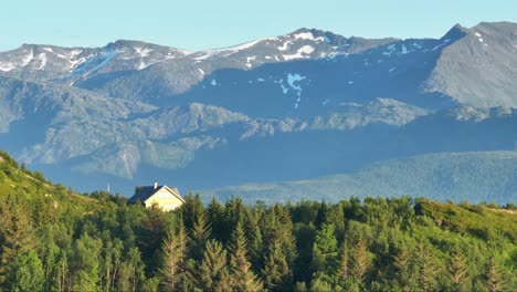 Vacation-Cabin-Amidst-Lush-Foliage-With-Mountain-Backdrop-In-Bovaer,-Senja,-Norway