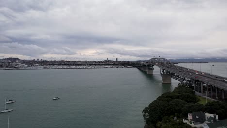Luftaufnahme-Der-Auckland-Harbour-Bridge-In-Auckland,-Neuseeland-Mit-Autoverkehr-Und-Booten-4k