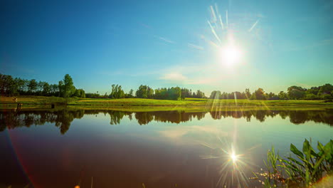 Sun-Setting-Over-Beautiful-Farm-Lake,-Blue-Summer-Sky,-Golden-Summer-Sun,-Rural-Farm,-Static,-Timelapse