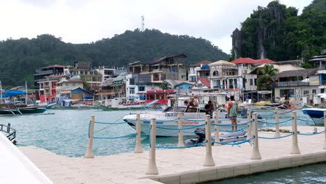 Scenic-view-of-El-Nido-town-with-houses,-shops-and-cafes-with-floating-dock-and-tour-boats-in-Palawan,-Philippines,-Southeast-Asia