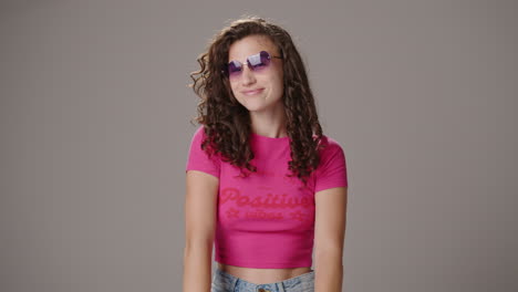 Brünettes-Mädchen-Setzt-Herzförmige-Sonnenbrille-Auf-Und-Posiert,-Studioaufnahme