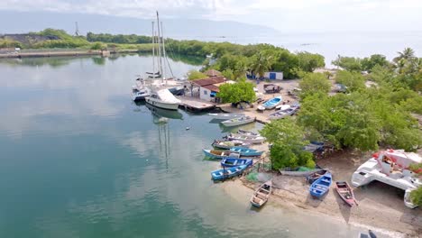 Drone-approaching-shot-of-anchored-boats-and-yachts-in-bay-of-Barahona-City,-Dominican-Republic