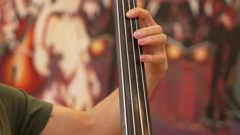 Left-hand-of-a-man-playing-the-strings-of-a-double-bass