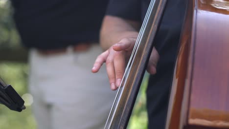 double-bass-closeup-slow-motion,-musician-playing-upright-bass-in-garden-wedding