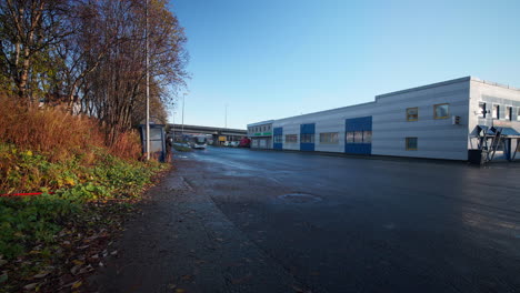 Tráfico-En-La-Calle-Asfaltada-Fuera-Del-Edificio-Industrial-En-Tromso,-Noruega