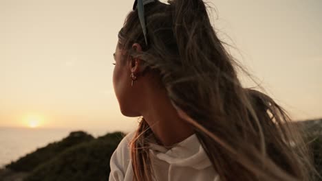 Slow-motion-shot-of-a-beautiful-female-model-watching-the-sunset-over-the-sea