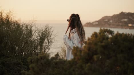 Slow-motion-shot-of-a-woman-playing-with-her-hair-and-watching-the-sunset