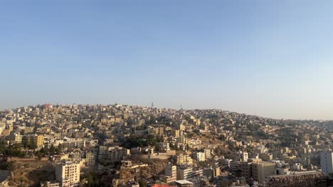 Amman-Stadt-Von-Oben-Der-Amman-Zitadelle-Mit-Jordanien-Flagge-Mit-Blick-Auf-Die-Wunderschöne-Skyline-Während-Des-Tages-4k