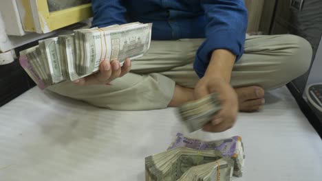 A-businessman-holding-a-stack-of-Indian-currency,-wealth,-Cash-in-hand,-Wide-shot