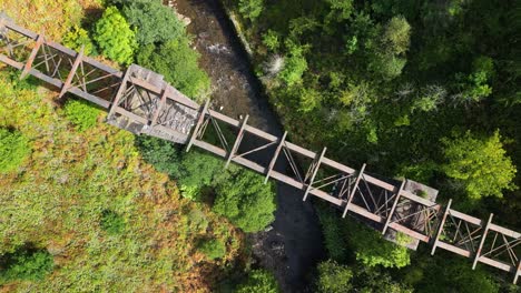 An-aerial-drone-shot-looking-down-on-an-abandoned-bridge-in-South-Wales-with-a-rotating-view