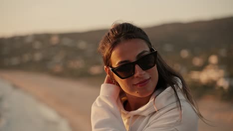 Slow-motion-bokeh-shot-of-an-attractive-female-at-the-coast-during-sunset