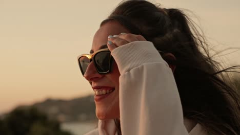 Zeitlupenaufnahme-Einer-Attraktiven-Frau-Mit-Sonnenbrille,-Die-Den-Sonnenuntergang-Beobachtet