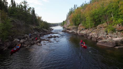 Epic-long-aerial-of-canoe-shooting-whitewater-rapids,-reversing-out-to-reveal-gorgeous-river-stretching-to-horizon