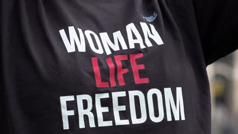 Una-Persona-Viste-Una-Camiseta-Negra-Que-Dice-“mujer,-Vida-Y-Libertad”-Durante-Una-Protesta-Que-Conmemora-La-Muerte-De-Mahsa-Amini,-Quien-Murió-Bajo-Custodia-De-La-Policía-Iraní-Después-De-Supuestamente-Violar-Las-Reglas-Del-Hijab.