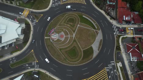 Drone-Shot-Over-Roundabout-in-Costa-Rica-with-Costa-Rican-Flag-Waving