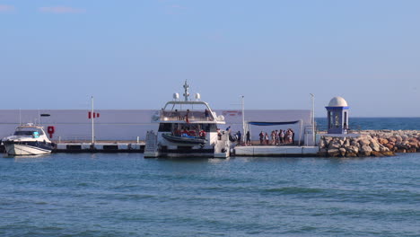 Leute,-Die-An-Bord-Der-Fly-Blue-Bootstour-Im-Hafen-Von-Marbella-Gehen,-Lustige-Urlaubstouren-Auf-Dem-Meer-In-Malaga,-Spanien,-Statische-4K-Aufnahme