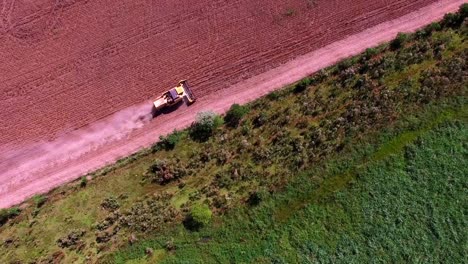 Aerial-View-Of-A-Farm-Tractor-Over-Soya-Fields-Harvesting-Near-The-Amazon-Forest-In-Brazil