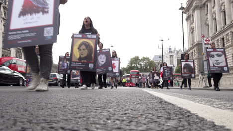 Protesters-march-along-Whitehall-while-holding-placards-that-depict-Mahsa-Amini-and-others-that-have-been-killed-in-women’s-rights-protests-in-Iran