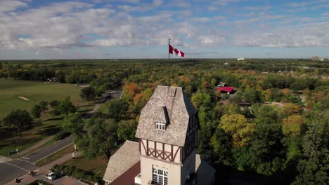 360-aerial-of-Canadian-flag-atop-Victorian-looking-tower,-4K