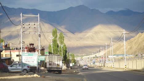 Taxi-moving-on-a-road-in-Leh-city-with-Upper-Himalayas-Landscape-in-Ladakh-India