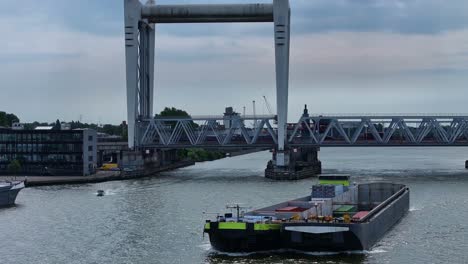Hintergrund-Der-Eisenbahnbrücke-über-Die-Alte-Maas,-Eine-Containerschiff--Und-Schnellbootfahrt