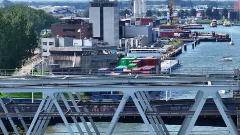Container-vessel-moored-at-the-city-of-Dordrecht-near-the-railway-bridge,-aerial