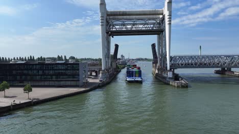 Container-vessel-passes-under-the-Railway-Bridge-across-Oude-Maas-River,-Dordrecht