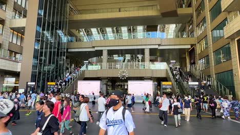 Slow-tilting-shot-showing-commuters-walking-through-Osaka-Train-Station,-Japan
