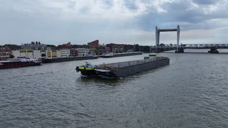 Aerial-dolly-footage-of-Container-Barge-on-the-river-Oude-Maas-at-Dordrecht,-Netherlands