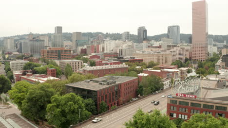 Wide-descending-aerial-shot-of-Portland-Oregon-old-town-sign-with-the-city-centre-in-the-background