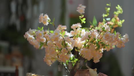 Eine-Vase-Mit-Wunderschönen-Pfirsichfarbenen-Blumen-Auf-Dem-Tisch